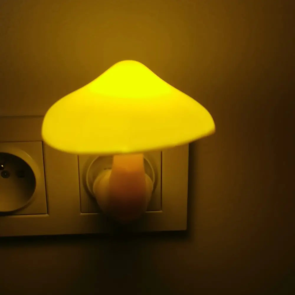 Mushroom-shaped night light plugged into a wall socket with a warm glow.