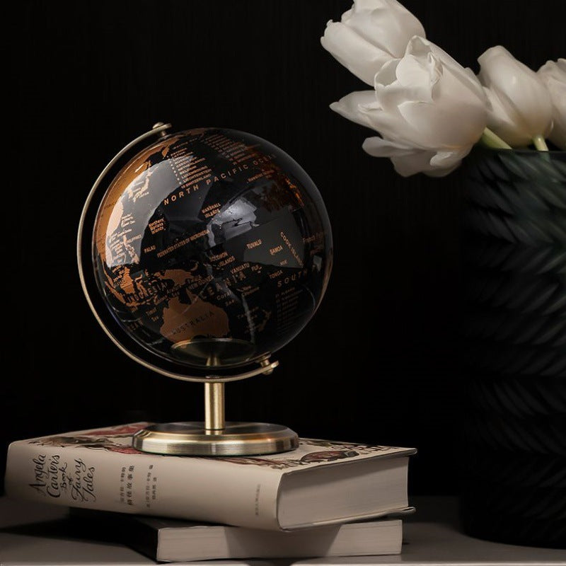 Small globe on a stack of books with white tulips in the background