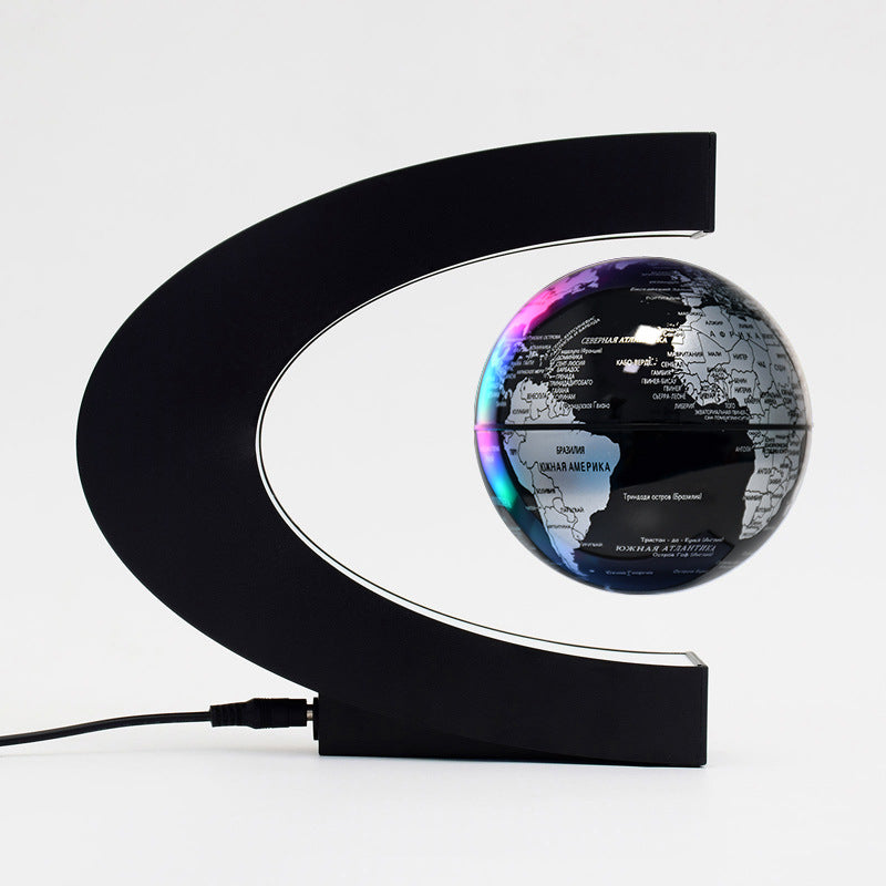 black and silver levitating globe with black base and white background