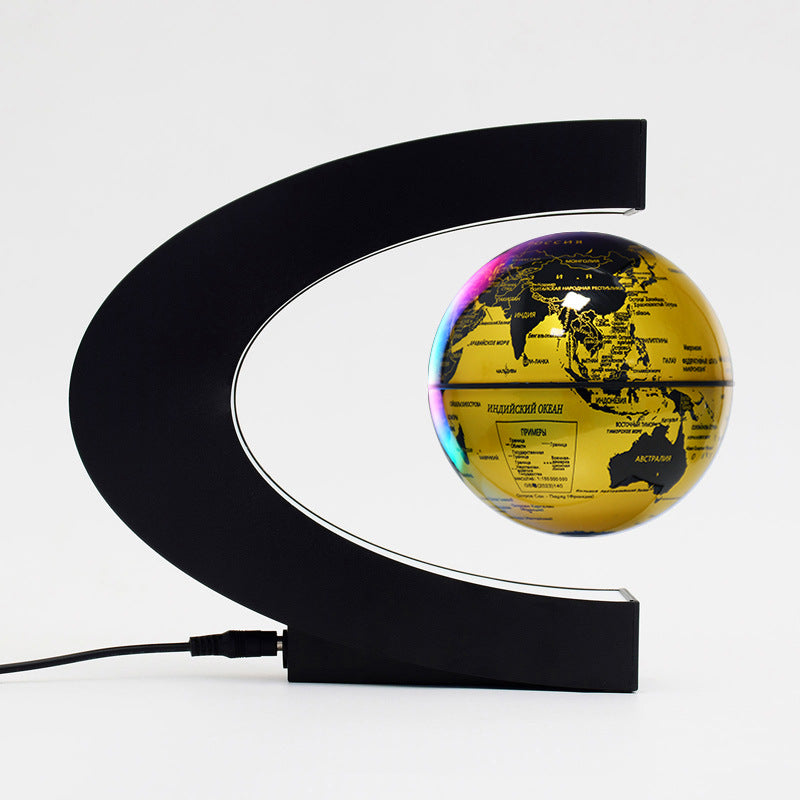 Gold globe with black curved stand on a white background