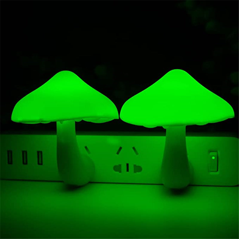 Two green mushroom-shaped night lights glowing in the dark.
