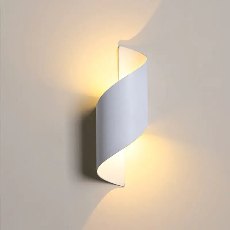 Wall-mounted light fixture with a wavy design on a plain wall.