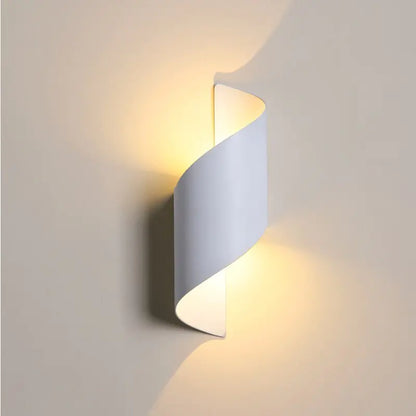 Wall-mounted light fixture with a wavy design on a plain wall.