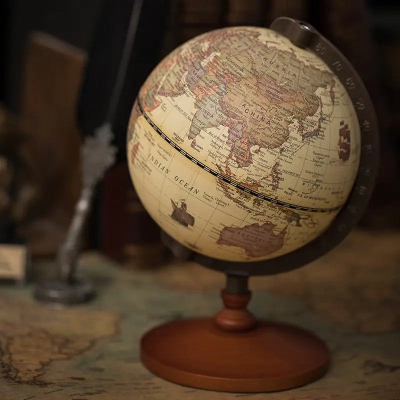 Vintage-style globe on a wooden stand with a blurred background